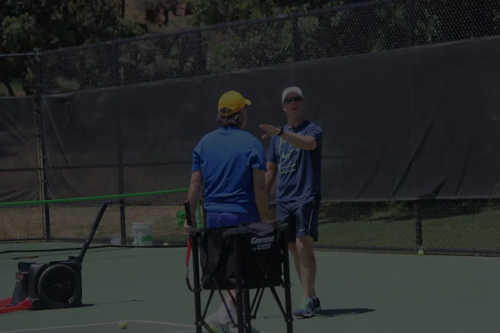Coach Mike Moriarty giving courtside instruction during a private tennis lesson