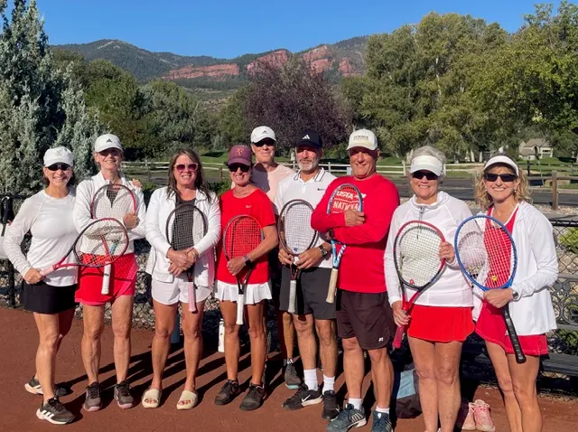 USTA tennis team with rackets in front of Animas Mountain red rocks near Durango, Colorado
