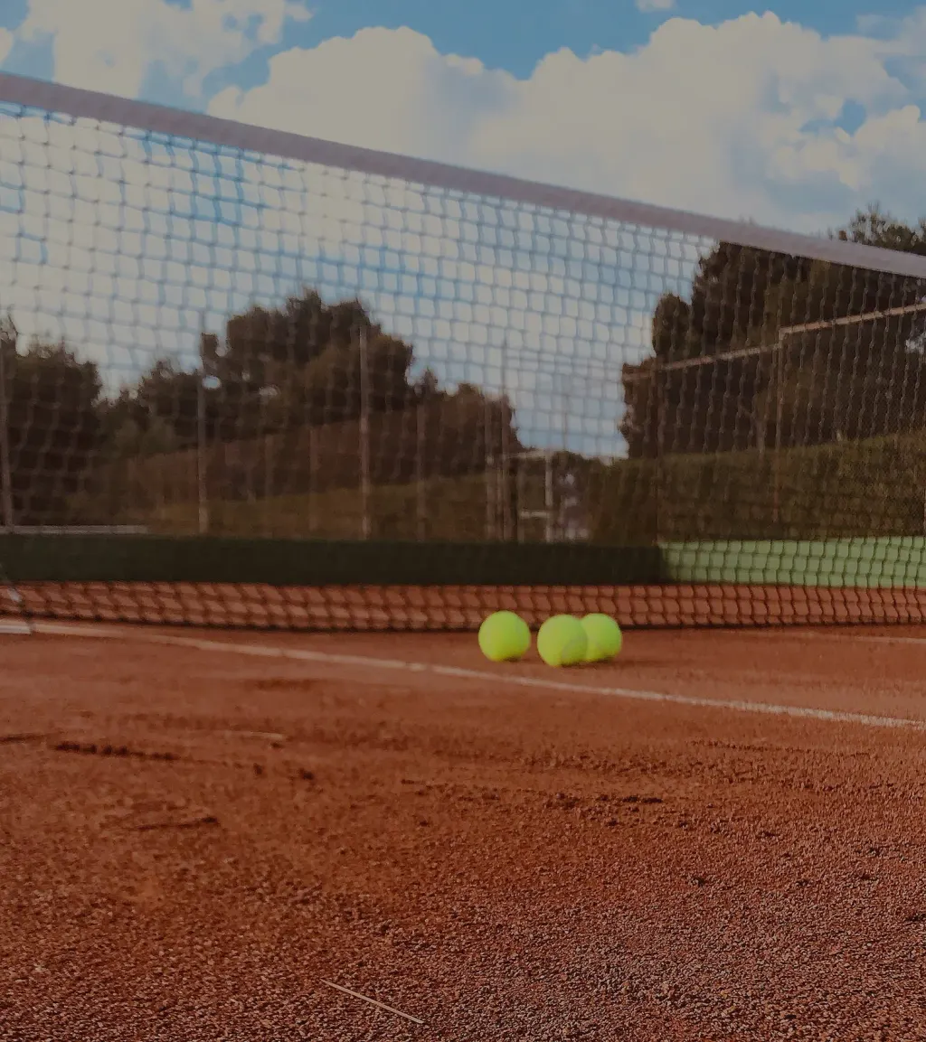 Tennis balls on clay court at Dalton Ranch with mountain backdrop